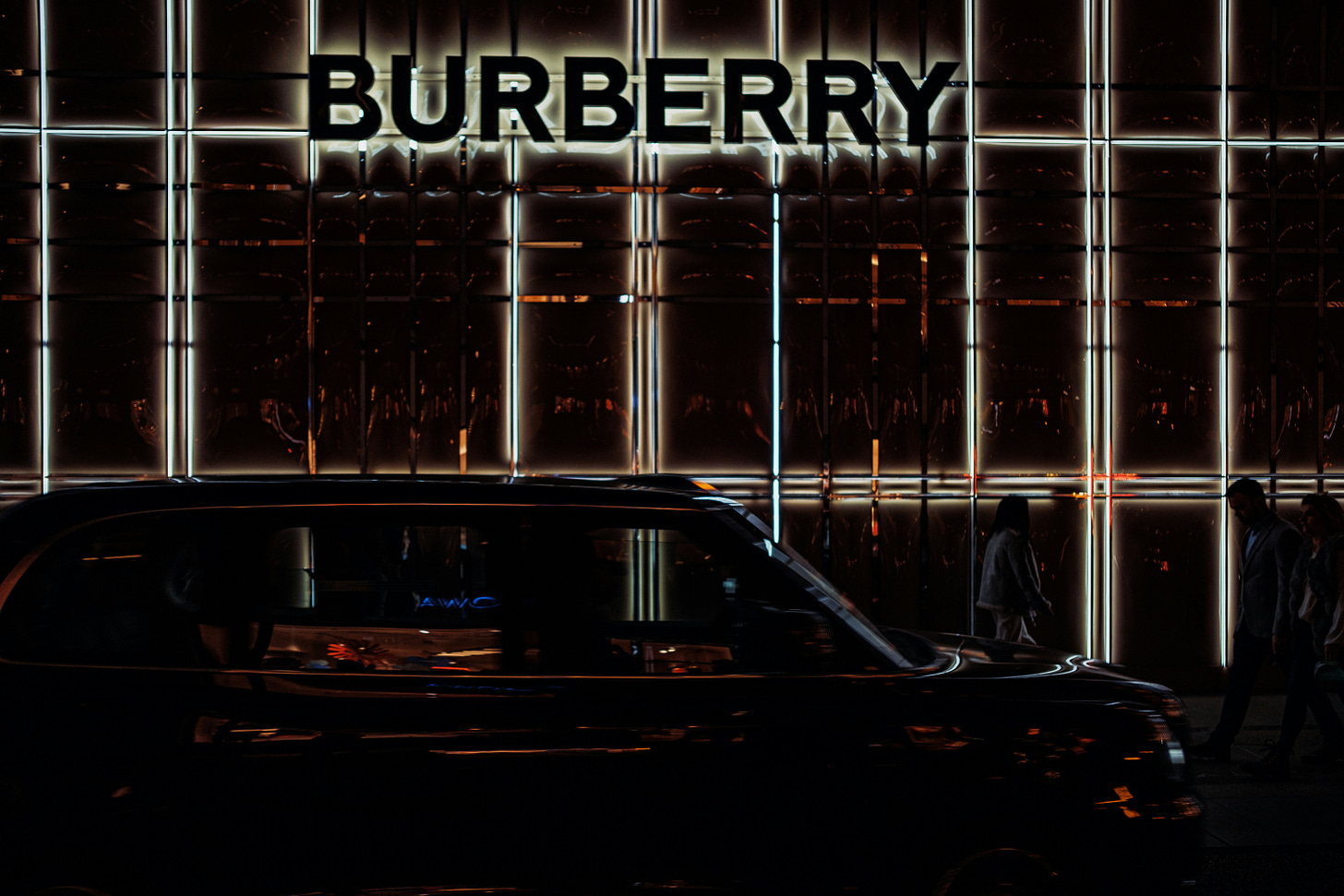 A black car parked in front of a Burberry building photo