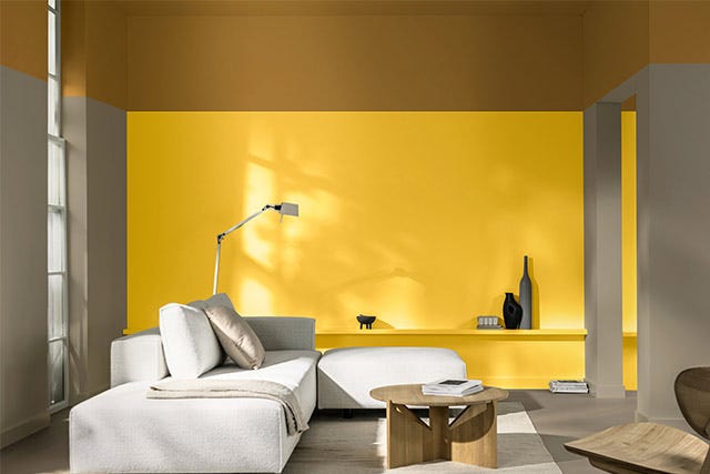 modern living room with True Joy feature wall in yellow and a neutral coloured room with off-white sofa