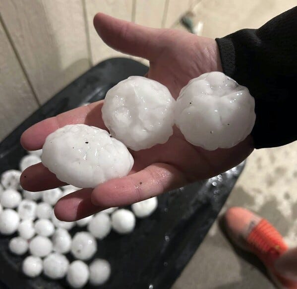 In this image provided by Jeremy Crabtree, large chunks of hail are shown, Wednesday night, March 13, 2024, in Shawnee, Kan. Volatile weather was honing in on parts of Kansas and Missouri Wednesday night, with some storms bringing massive chunks of hail