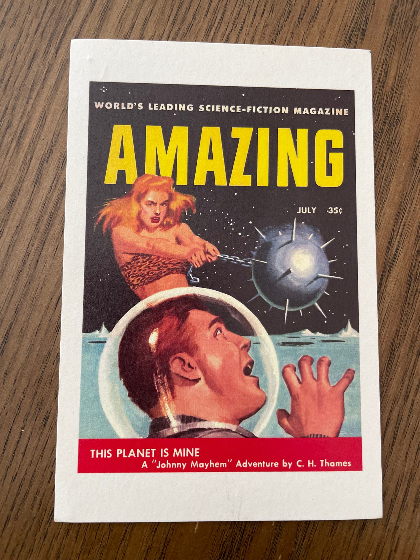 A post card made from the cover of the old sci-fi magazine AMAZING. The image is an illustration of a woman swinging a large mace at the head of an astronaut wearing a glass orb helmet.