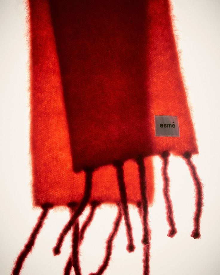 This may contain: three pieces of red wool with the word omme written on them