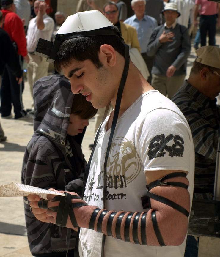 Ein Beter an der Westmauer in Jerusalem hat Tefillin gebunden