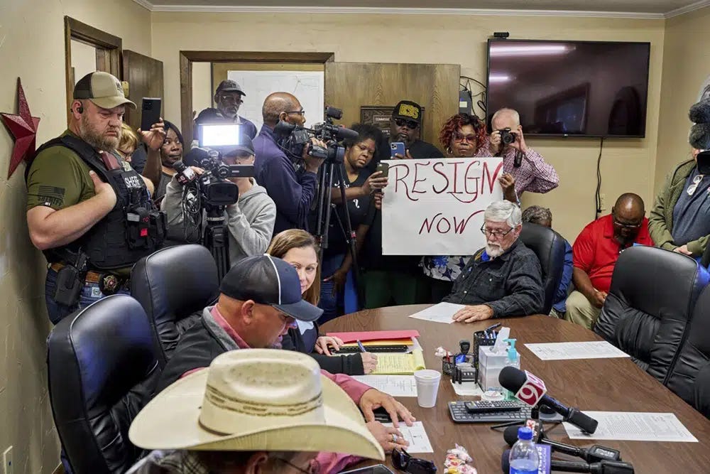 In this photo provided by the Southwest Ledger, people from Idabel, Okla., call for the resignation of several McCurtain County officials at a county commissioners meeting early Monday, April 17, 2023, after tapes with the officials' racist comments surfaced over the weekend. (Christopher Bryan/Southwest Ledger via AP)