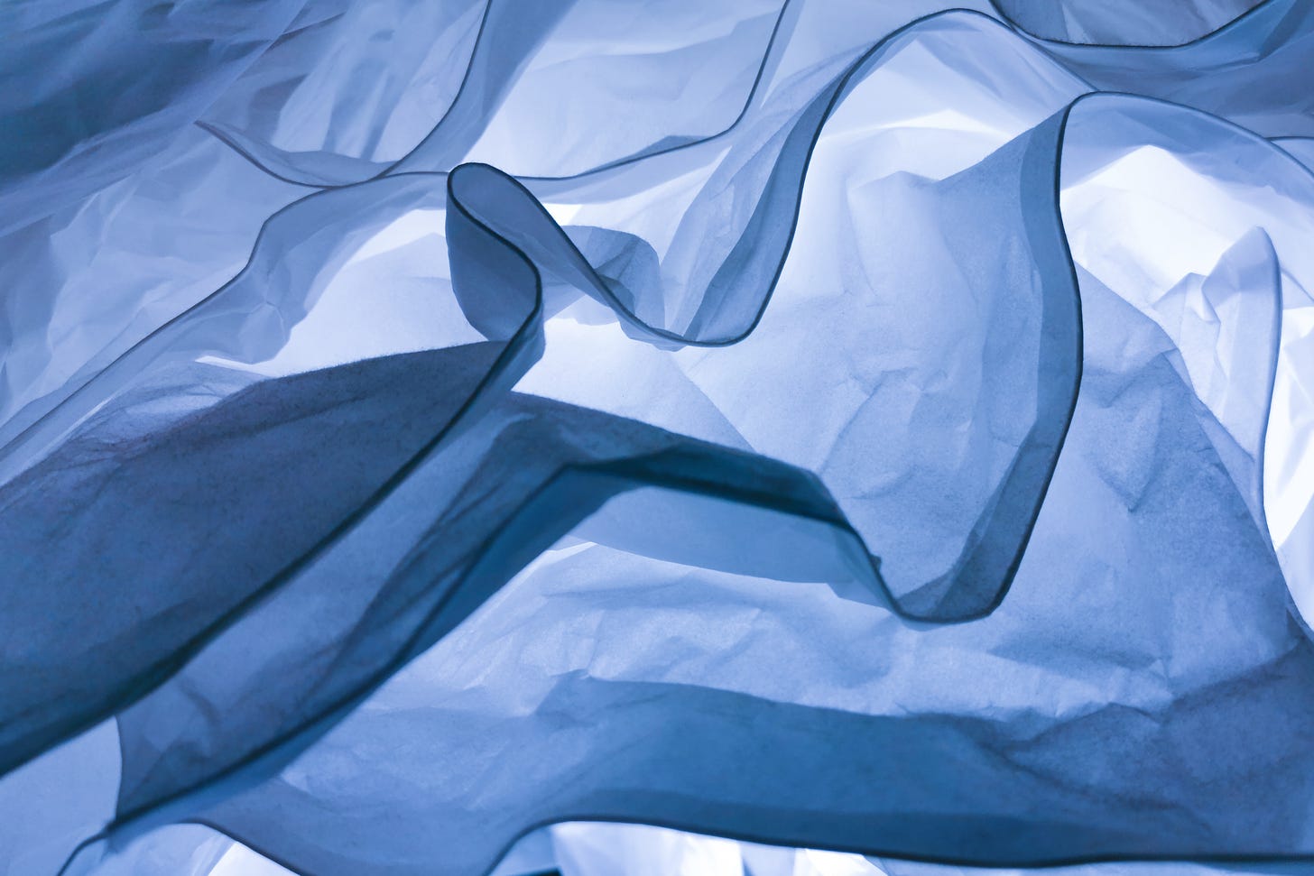 Abstract photo, waves of fabric backlit with bluish light