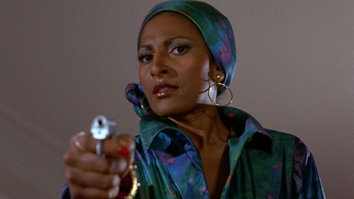 ‎Pam Grier, in aquamarine, holds a gun in Foxy Brown (1974)