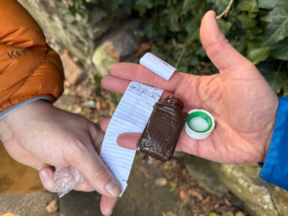 two hands hold a geocaching logbook