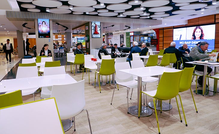 A photo of the Pran Central food court. There are people sitting at tables.