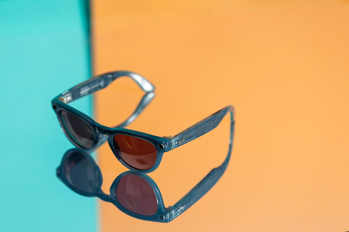 A photo showing the Ray-Ban Meta Smart Glasses on a blue and yellow background