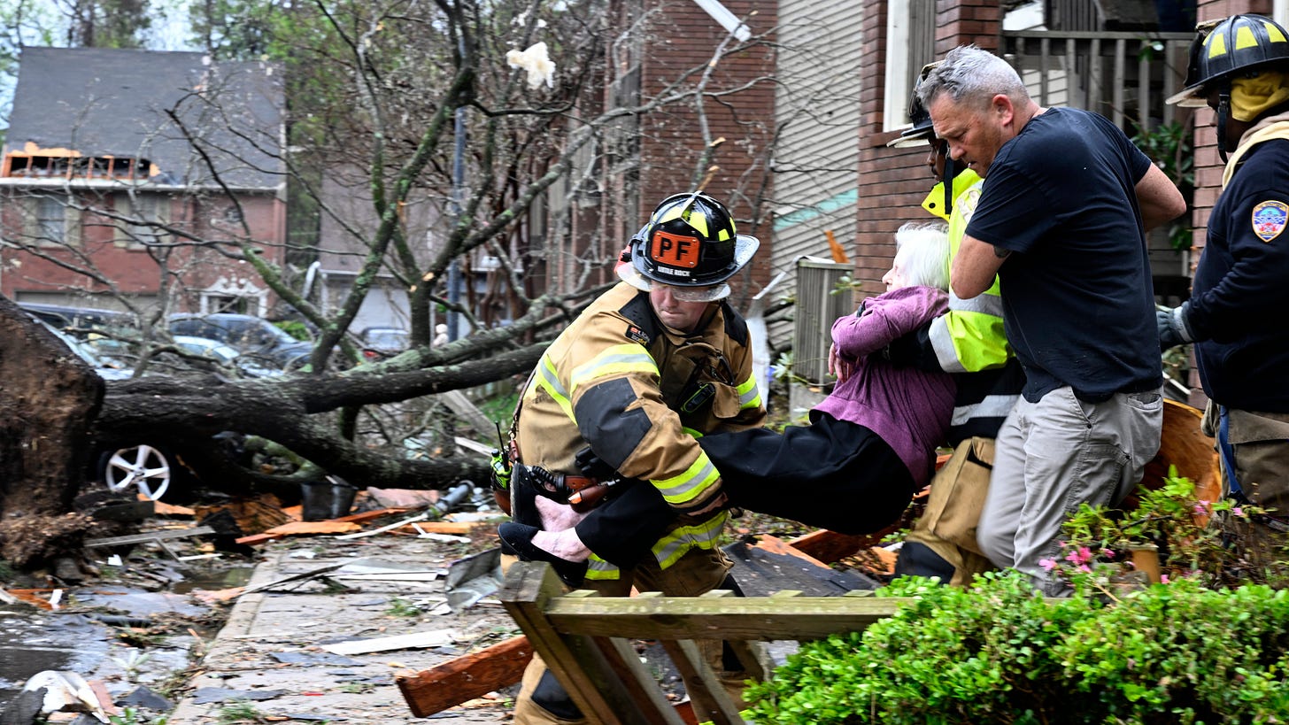 Firefighters carry a woman out of her condo after her complex was damaged by a tornado, Friday, March 31, 2023 in Little Rock, Ark. A monster storm system tore through the South and Midwest on Friday, spawning tornadoes that shredded homes and shopping centers, overturned vehicles and uprooted trees as people raced for shelter (Stephen Swofford/Arkansas Democrat-Gazette via AP)