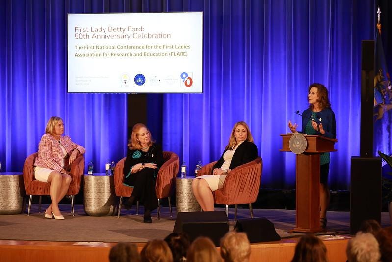 A group of women sitting at a podium

Description automatically generated