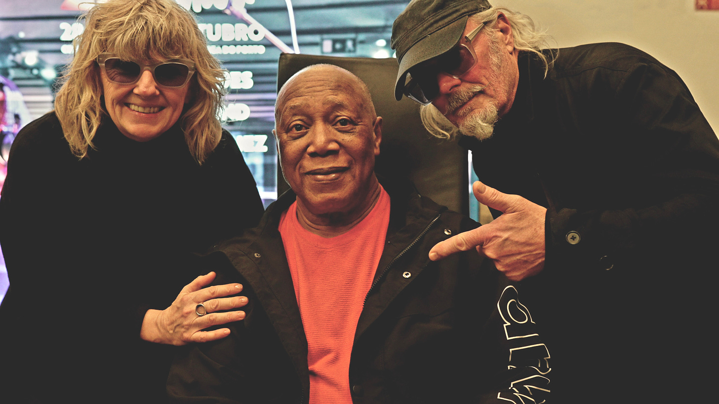 Three people smiling having a photo taken