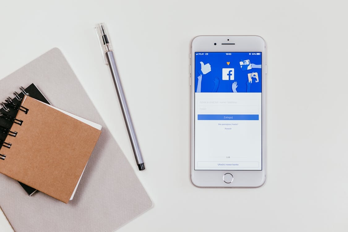 Free Minimalist workspace featuring a smartphone with social media login and notepad. Stock Photo Free Minimalist workspace featuring a smartphone with social media login and notepad. Stock Photo