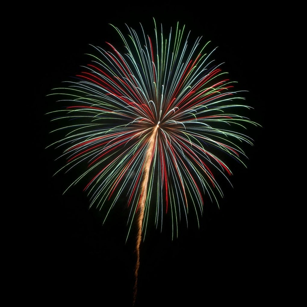 A colorful fireworks is lit up in the night sky