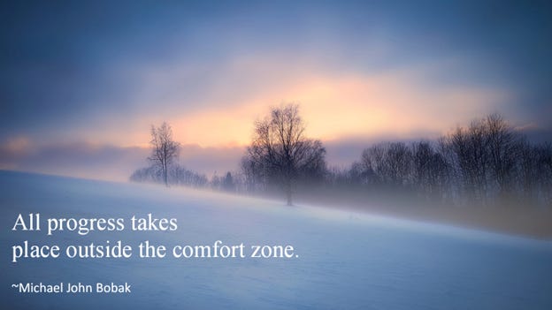 Cold winter scene of forest and field with blowing snow at sunset. Inset caption: “All progress takes place outside the comfort zone.” 