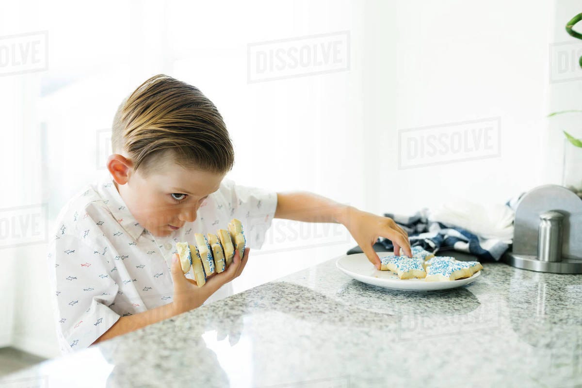 Boy (8-9) stealing cookies - Stock Photo - Dissolve