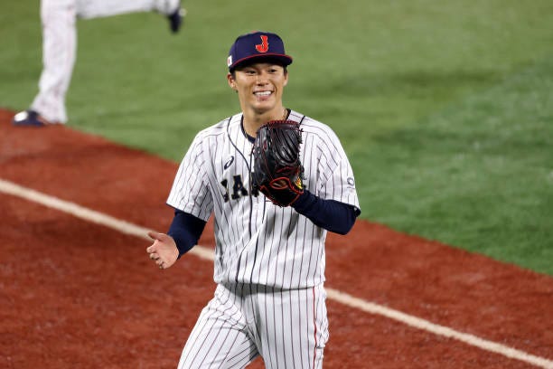 Yoshinobu Yamamoto of Team Japan reacts as he walks back to the dugout against Team Republic of Korea during the semifinals of men's baseball on day...