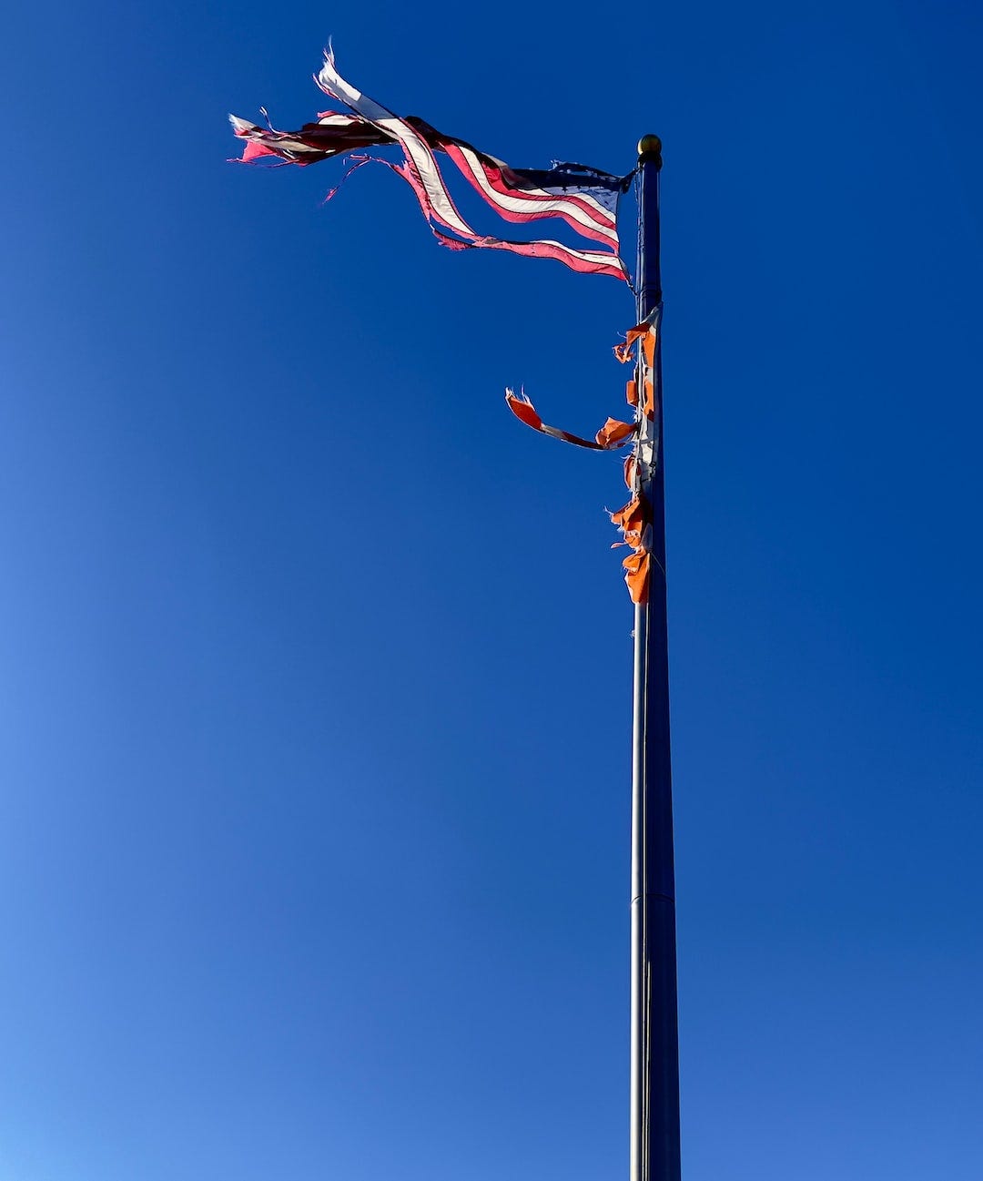 flag of us a on pole under blue sky