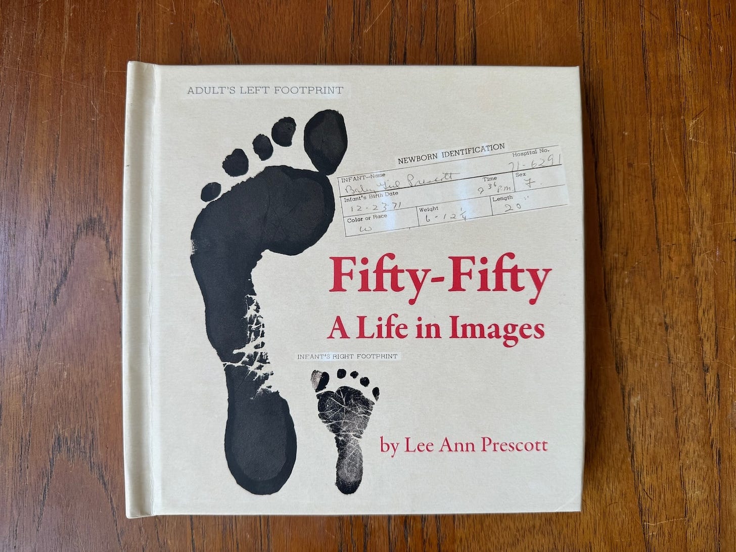 A book with the title Fifty-Fifty: A Life in Images with prints of an adult foot and a baby foot