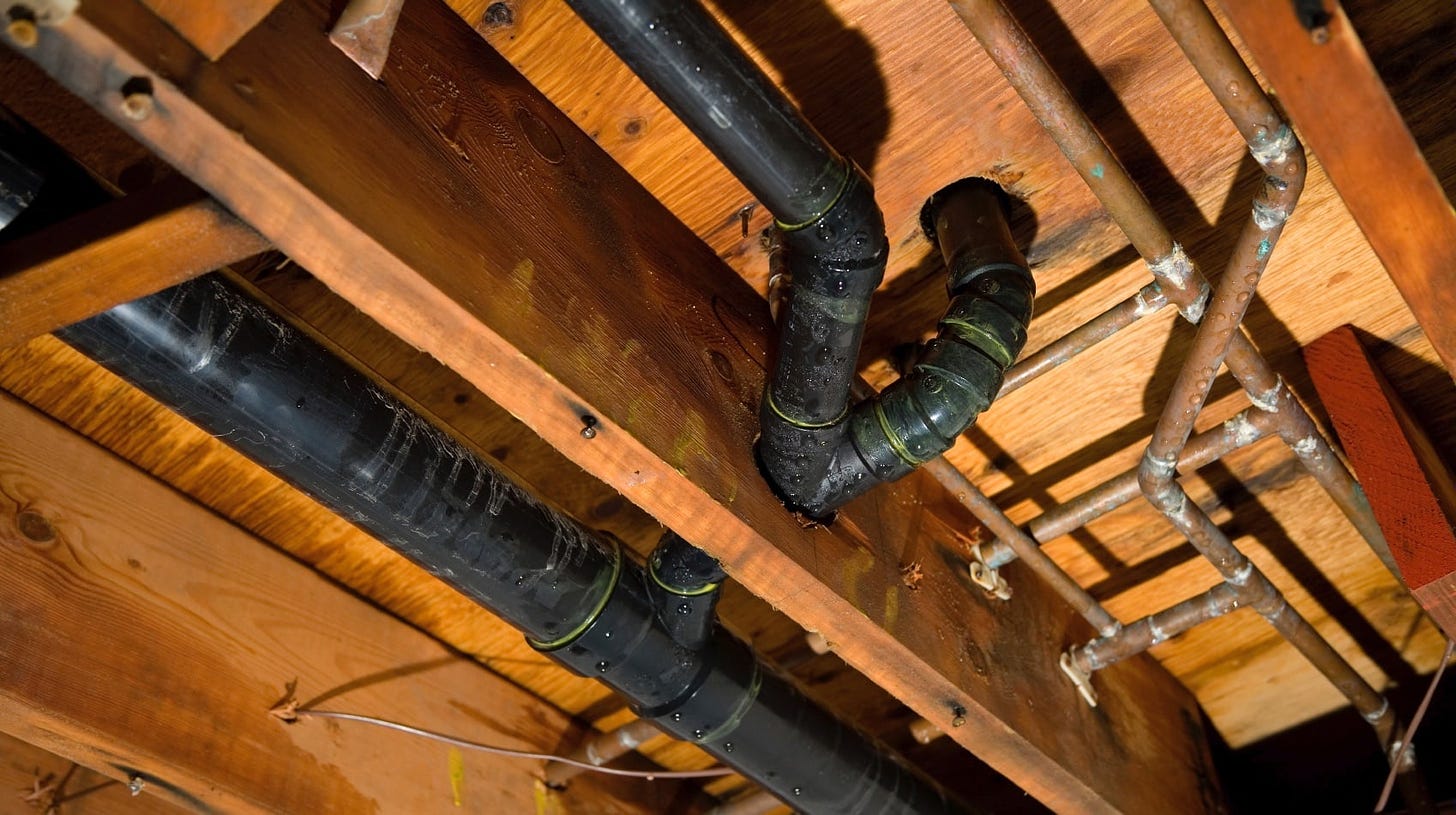 Plumbing in a basement going through floor joists. Home inspectors do not like to see holes in the floor joists