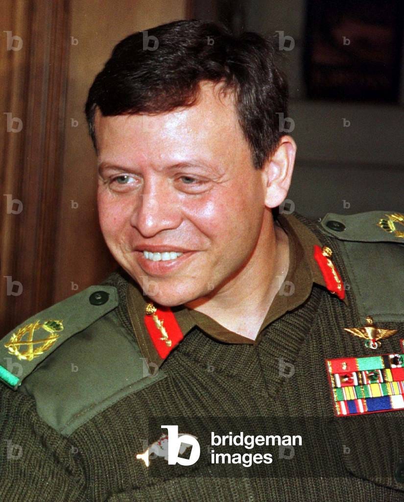 Jordan's King Abdullah in military uniform smiles [as he welcomes Spain's Crown Prince Felipe in Amm.., 1999-0