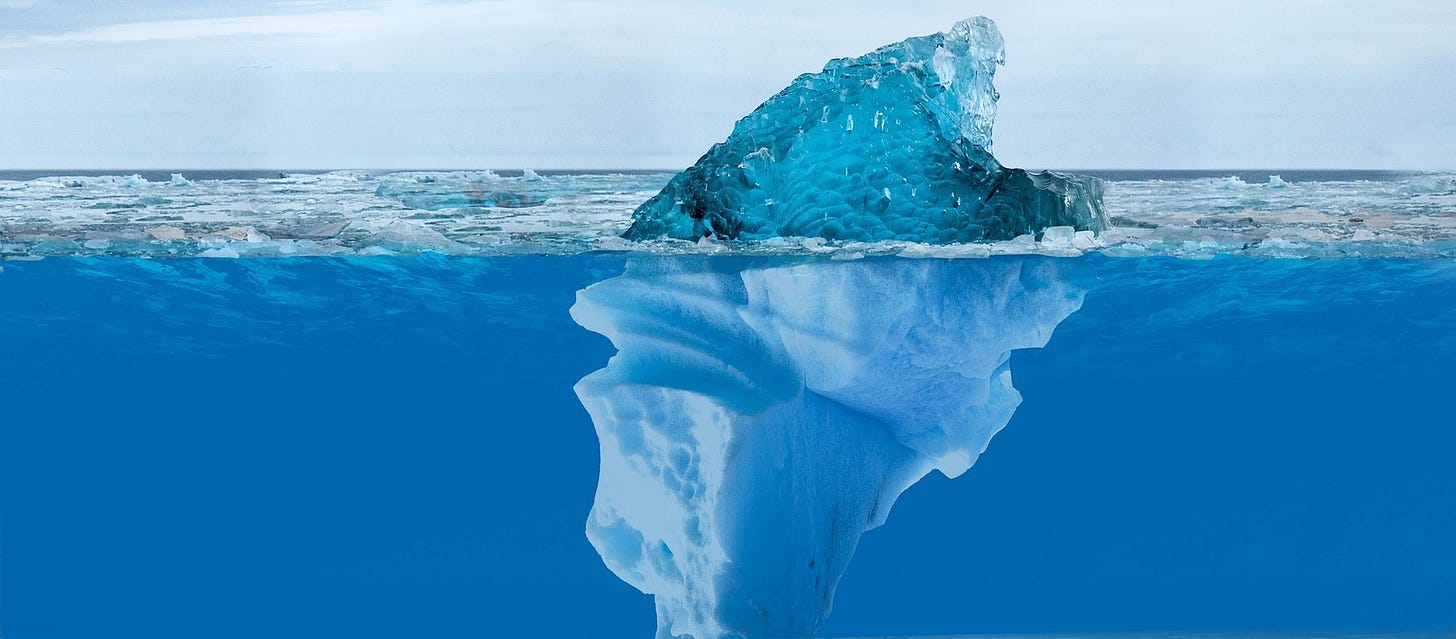 A picture of an iceberg floating at sea, the majority of its bulk visualized underwater.