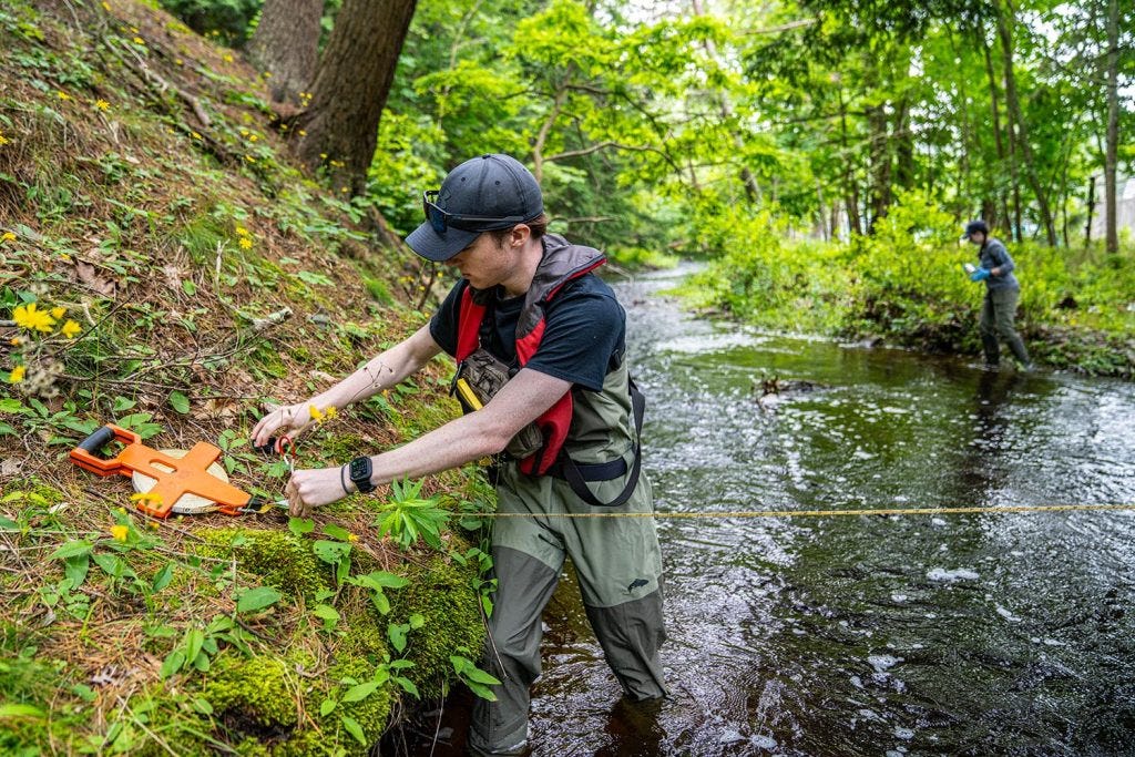 A photo of two people in a stream