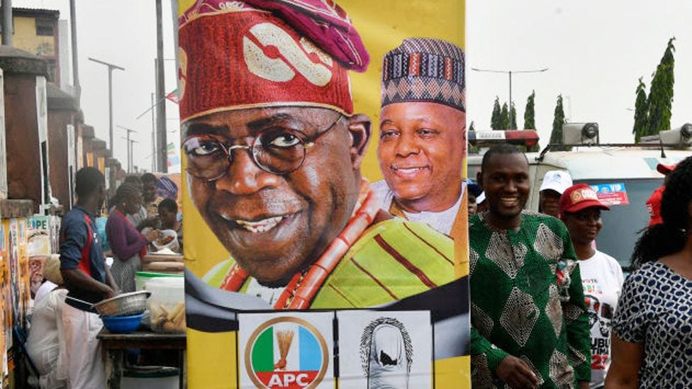 Supporters walk past a banner with a photograph of the candidate of the ruling All Progressives Congress (APC) Bola Tinubu during the last rally of the party in Lagos on 21 February 2023