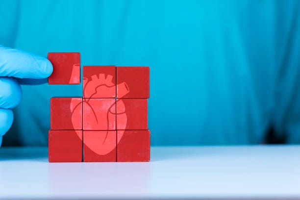 concept of heart transplant and heart diseases, cardiomyopathy, arrhythmia. the doctor's hand organizes the wooden cubes. heart donor. - myocarditis bildbanksfoton och bilder