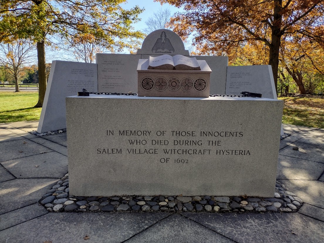 Stone memorial shaped like altar with image of minister, and stone in front