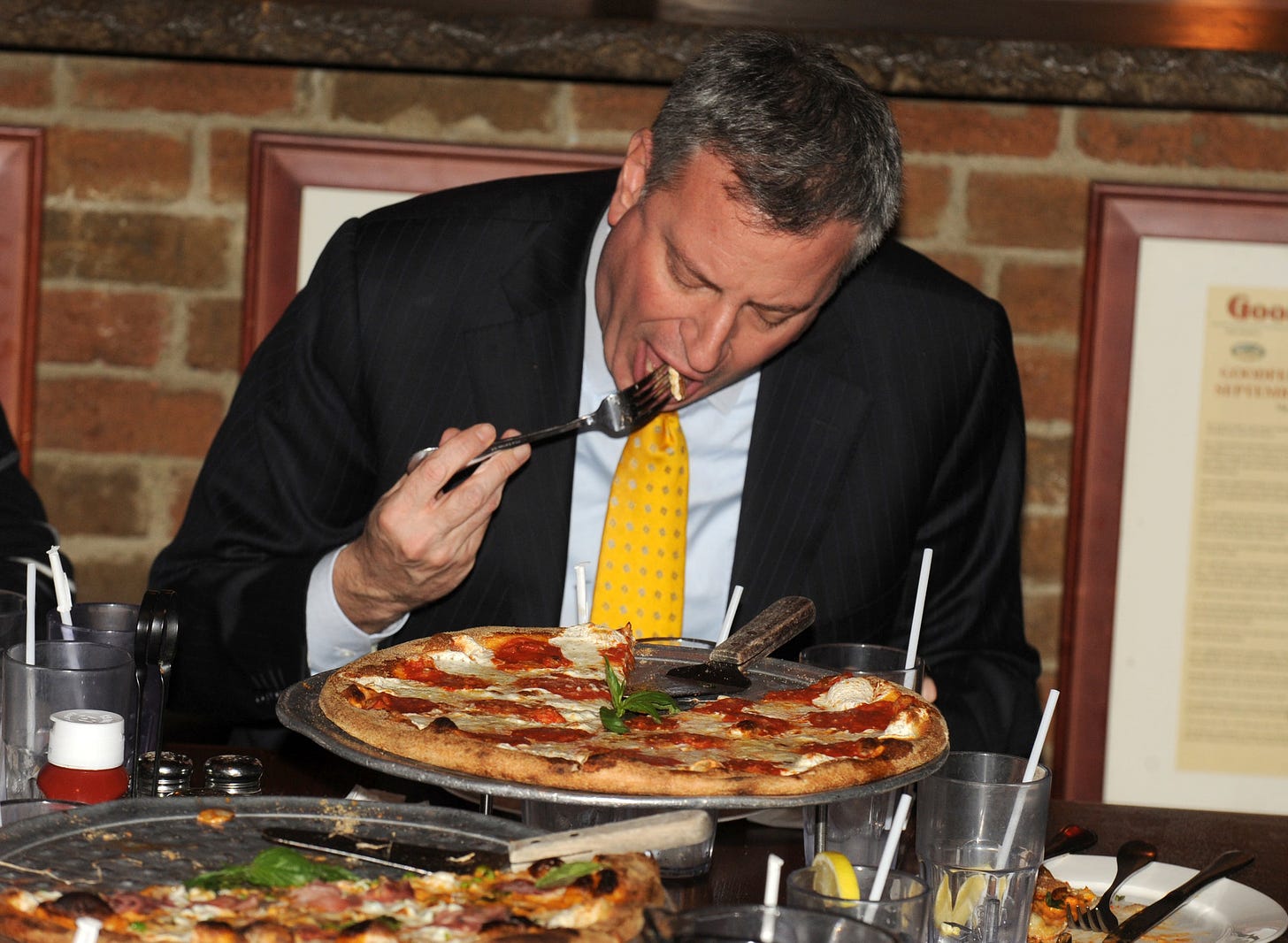Il sindaco di New York Bill de Blasio mangia una pizza con la forchetta