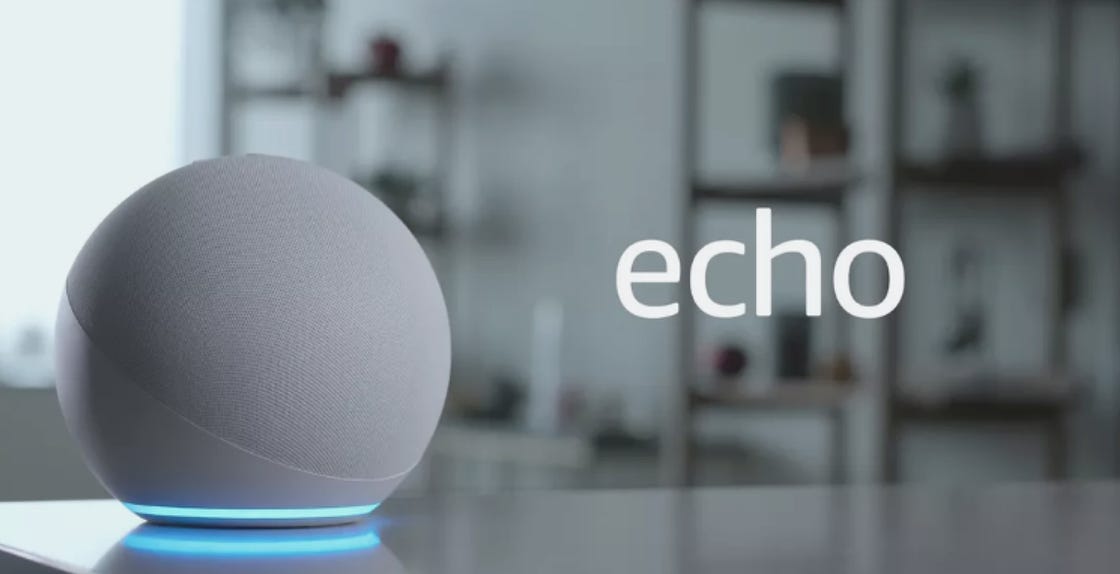The fourth-generation Echo device is a cloth-covered sphere with a halo at the base, contrasting with the squat plastic cylinders of earlier-generation Echoes.
