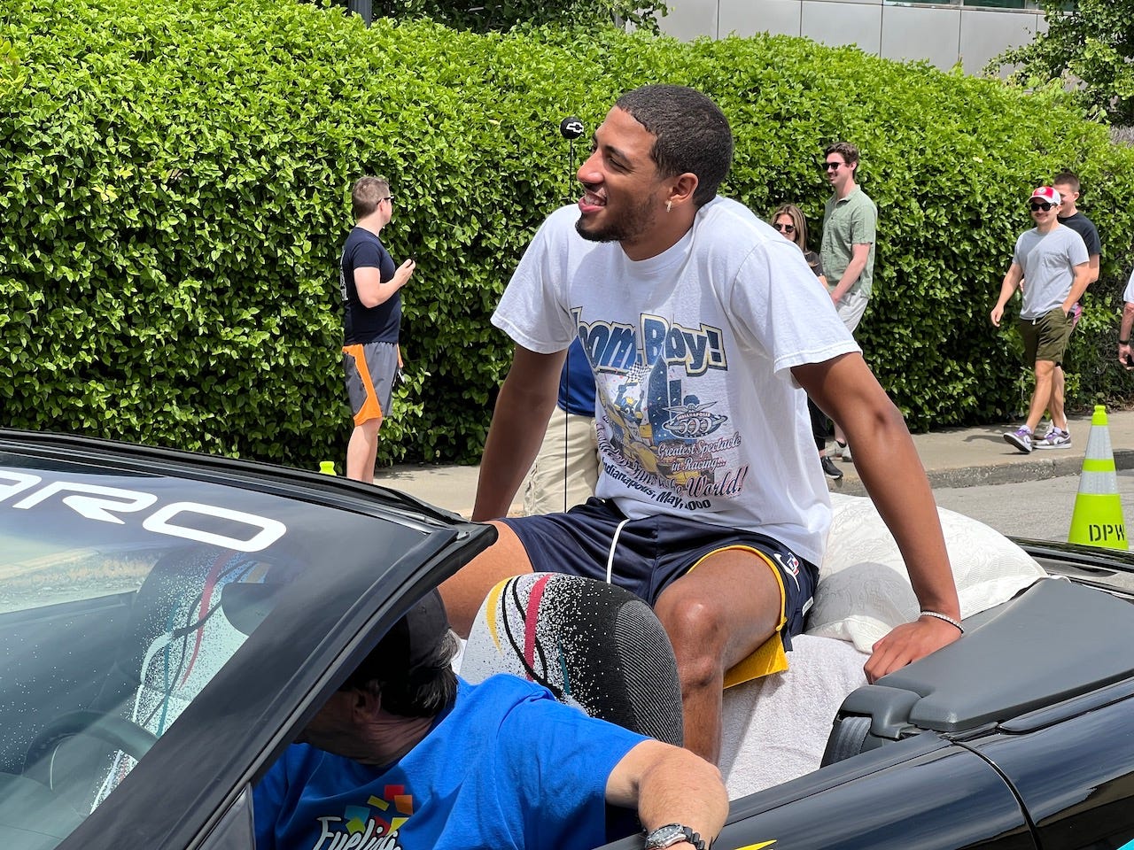 Tyrese Haliburton is in the back of a Chevy convertible as he rides in the 500 Festival Parade with a vintage Zoom, Baby! Pacers t-shirt.