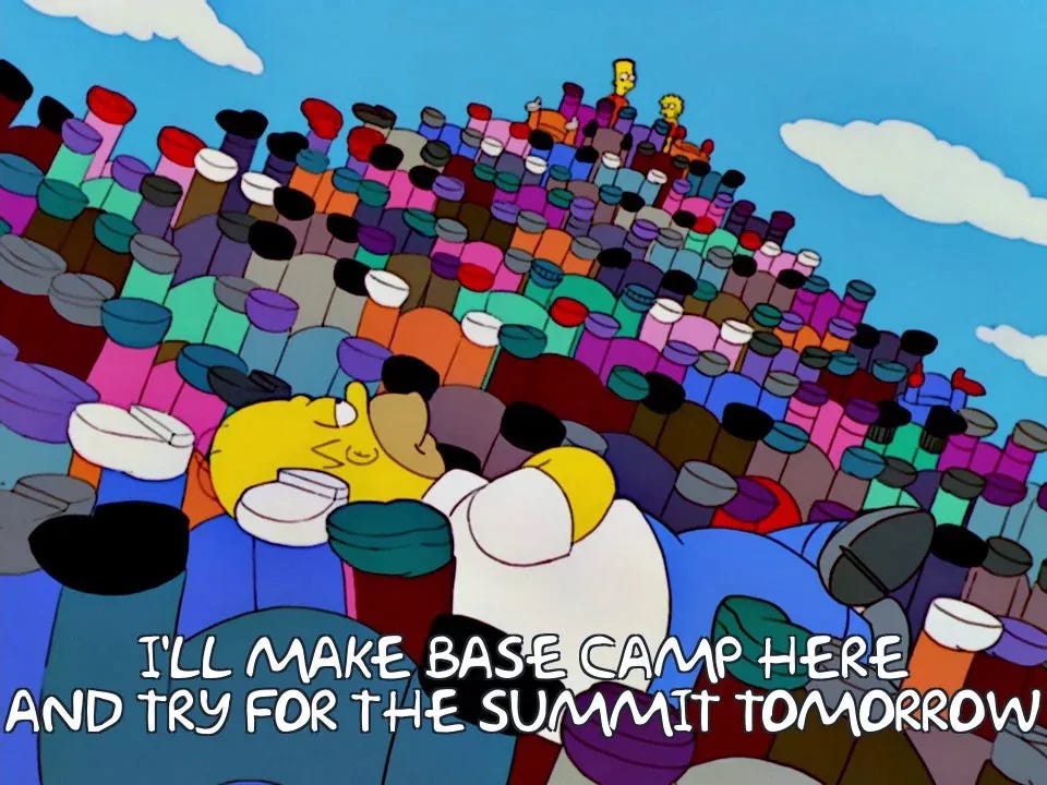 Homer Simpson lying in legs of people in a human pyramid, saying "I'll make base camp here and try for the summit in the morning"