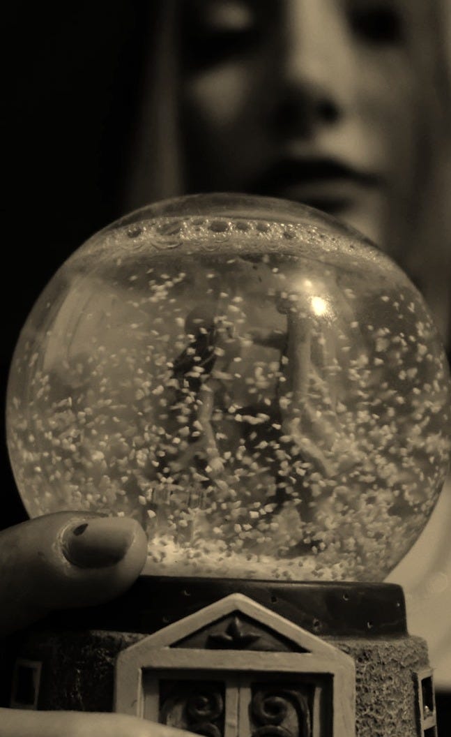a woman holding a snow globe in her hand