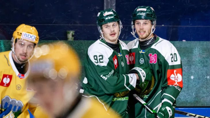 Two Färjestad players celebrating a goal together.