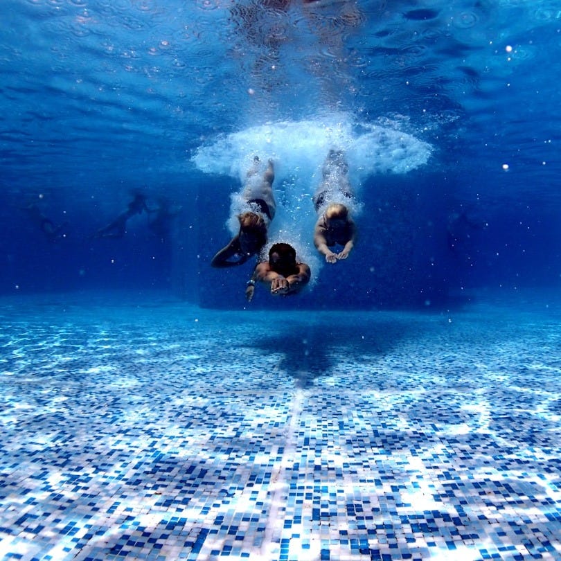 three person diving on water