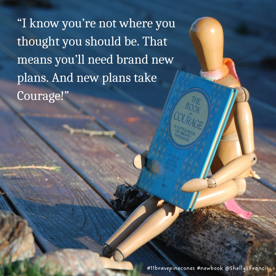 A wooden manikin, Emotikin, holding a little book of courage and the quote "I know you're not where you thought you should be. That means you'll need brand new plans. And new plans take Courage!"