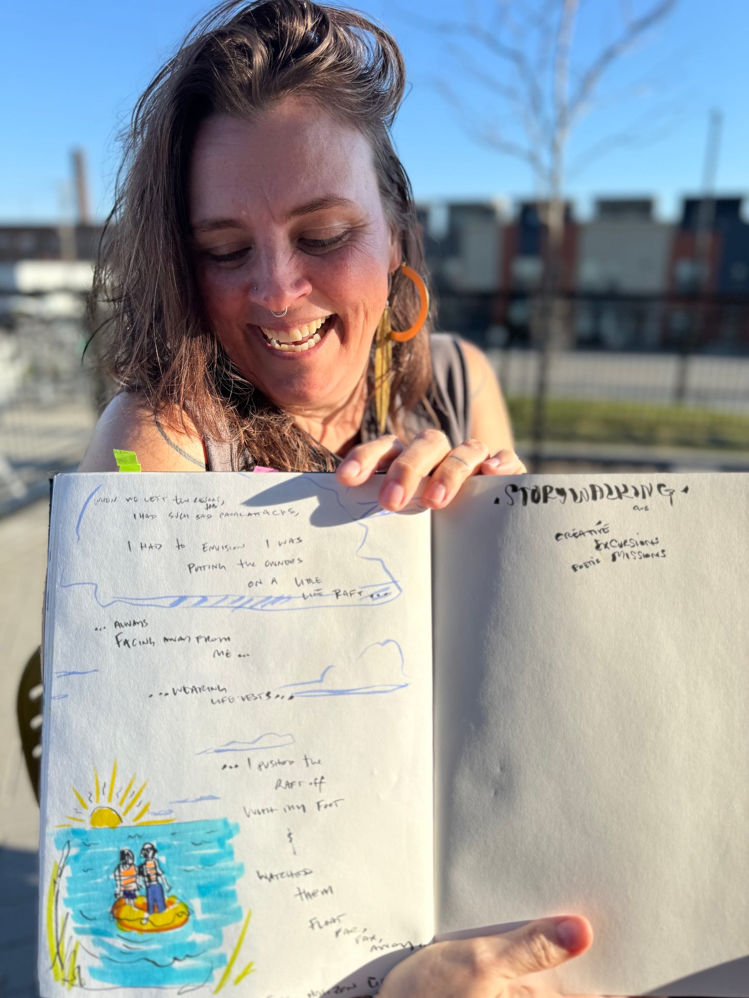 artist lisette murphy holds up her sketchbook and laughs. there is writing and a drawing of a yellow raft on blue water.