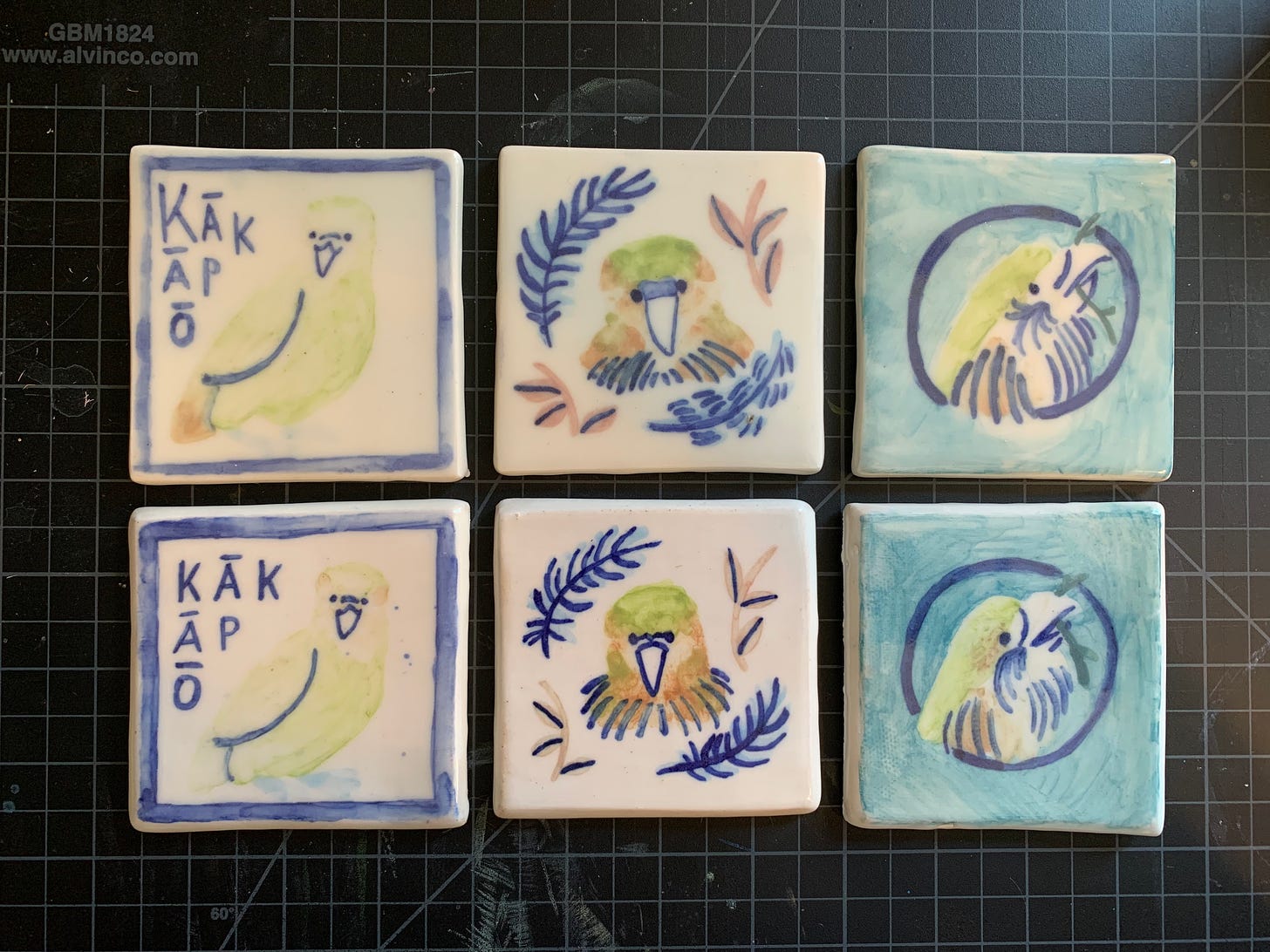 porcelain and stoneware test tiles with kakapo drawings applied with underglaze