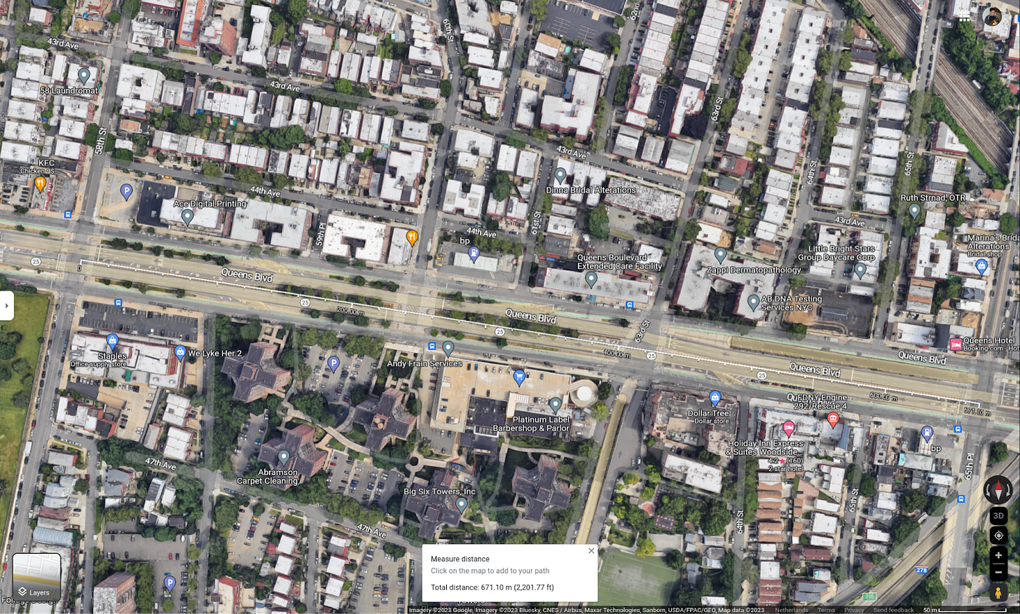 Image shows Queens Boulevard with four intersecting roads and the maps distance measuring tool reading less than 700 meters.
