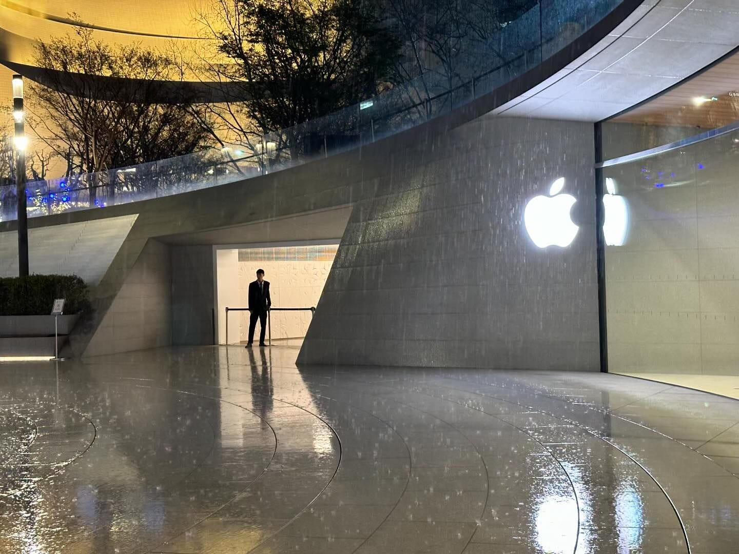 The first rainstorm at Apple Jing'an. One person is standing alone at the metro station entrance adjacent to the store.