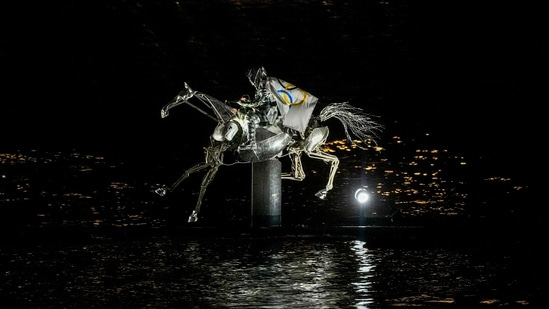 A performer on a mechanical horse carries the Olympic flag down the river Seine in Paris, France, during the opening ceremony of the 2024 Summer Olympics, Friday, July 26, 2024. (AP Photo/Lindsey Wasson)(AP)