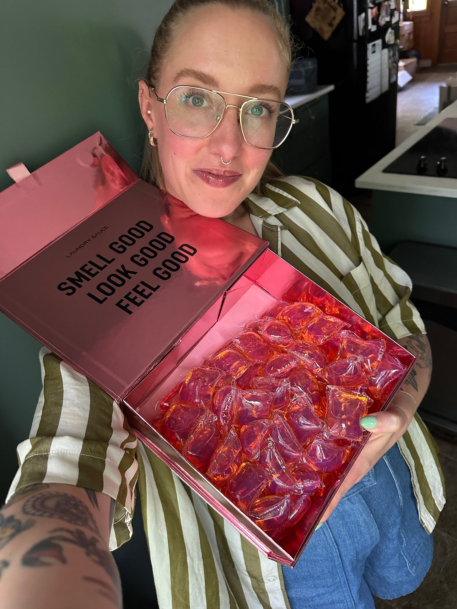 woman holding an open box of laundry sauce laundry pods