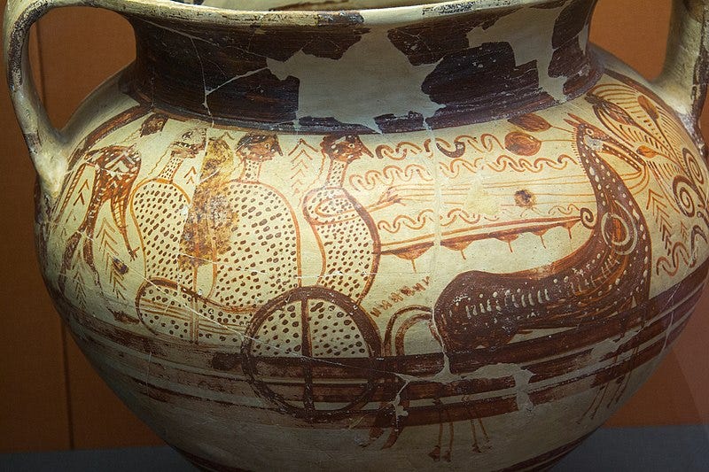 color photograph of an early Greek vase with orange-brown figures driving a chariot
