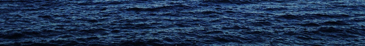 The surface of a dark blue ocean, rippling with small waves