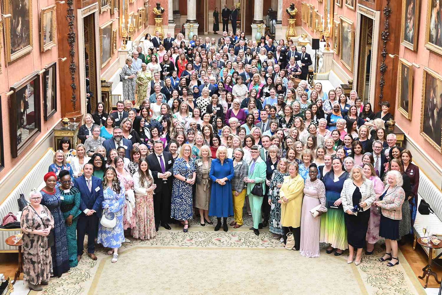 A general view as Queen Camilla (C) poses with guests as she hosts a reception recognising those who support survivors of sexual assault and the relaunch of the Wash Bags Project at Buckingham Palace on May 1, 2024 in London, England. The Wash Bags scheme provides a wash bag of toiletries, donated by Boots, to people who have been affected by rape and sexual abuse after they have undergone forensic examination.