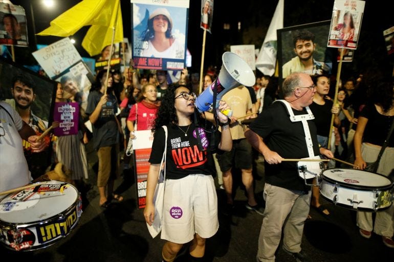 a young woman talks into a loud hailer at a protest