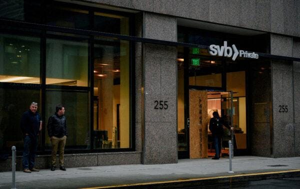  Customers wait outside as an employee enters the Silicon Valley Bank branch office in downtown San Francisco, Calif., on March 13, 2023. (Kori Suzuki/File Photo/Reuters)