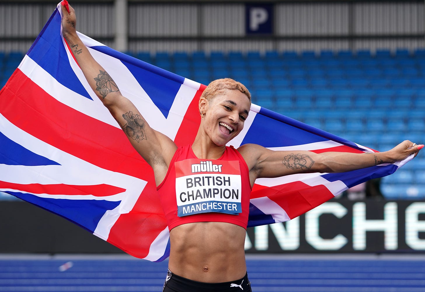 Jodie Williams holding the Union Jack flag behind her after winning the women's 200m at the Muller British Athletics Championships in 2021