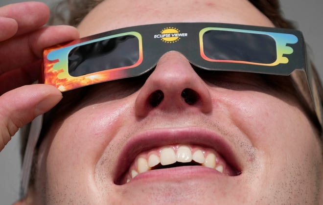 A man wears special glasses to watch the partial solar eclipse in Trafalgar Square in London.